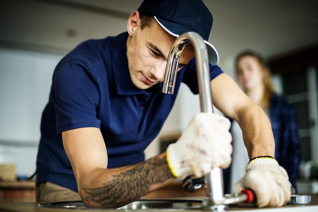 Plumber fixing a kitchen sink